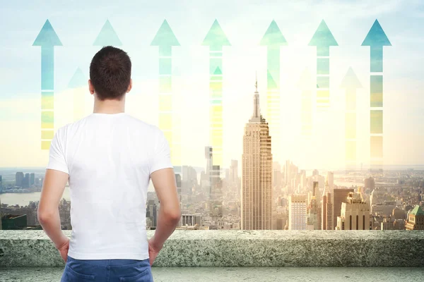 Visão traseira do jovem empresário no telhado olhando para a cidade de Nova York com setas para cima. Conceito para a frente — Fotografia de Stock