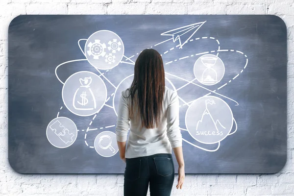 Back view of young woman drawing creative sketch on chalkboard. Leadership concept — Stock Photo, Image