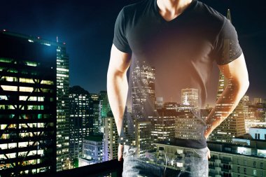 Soyut gece şehir arka plan üzerinde rahat tişörtlü düşünceli genç adam. Araştırma kavramı. Çift pozlama