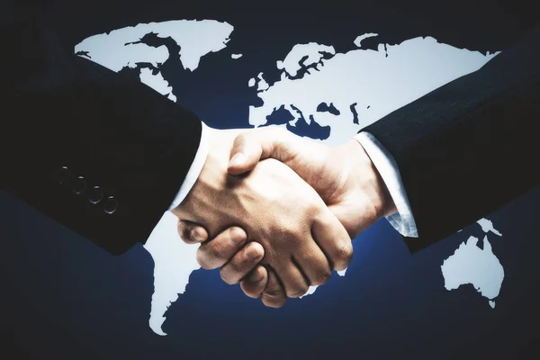 Side view of handshake on dark background with map. Networking concept — Stock Photo, Image