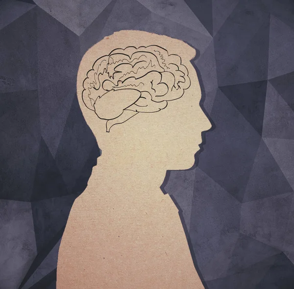 Boční pohled na lepenkové muž silueta s nakreslené mozku na tmavém pozadí polygonální betonu. Brainstorm koncept. 3D vykreslování — Stock fotografie
