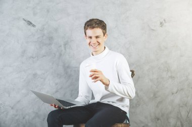 Kahve ve bir dizüstü bilgisayar ile neşeli adam 