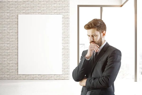 Hombre reflexivo y póster en el interior — Foto de Stock