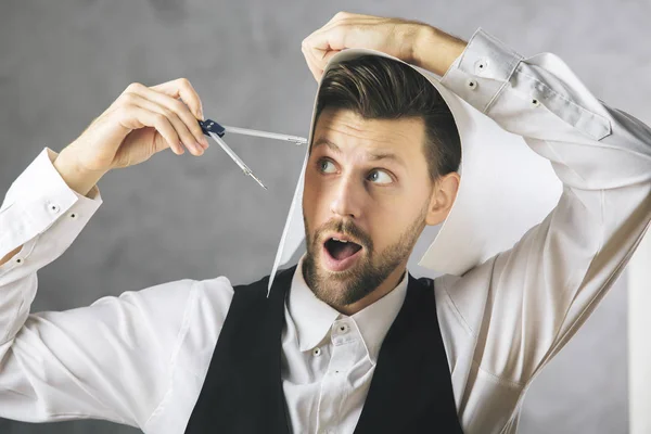 Arquitecto loco midiendo su cabeza con una brújula sobre fondo de hormigón —  Fotos de Stock