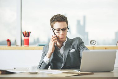 Adam telefonda laptop kullanarak 