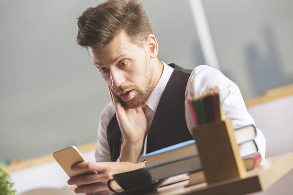 Geschäftsmann mit Smartphone überrascht — Stockfoto