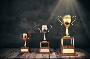 Ahşap sahne beton zemin üzerine altın, gümüş ve bronz winnner'ın cups ile. Liderlik kavramı. 
