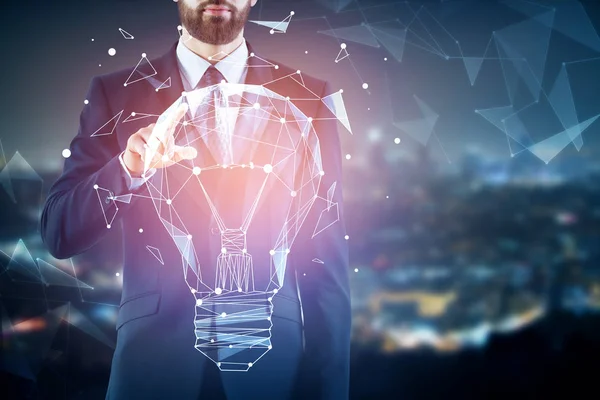 Hombre de negocios apuntando a la lámpara poligonal iluminada creativa abstracta sobre fondo borroso de la ciudad nocturna. Concepto energético . — Foto de Stock