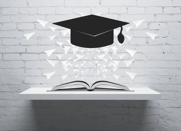 Abstract levitating mortarboard above shelf with open book and paper planes. Brick wall background. Graduation concept. 3D Rendering — Stock Photo, Image