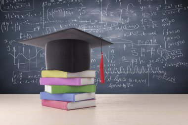 Soyut mezuniyet şapka ve renkli kitap yığın ahşap yüzey üzerine yerleştirilir. Arka planda matematiksel formüller ile kara tahta. Eğitim kavramı. 3D render 