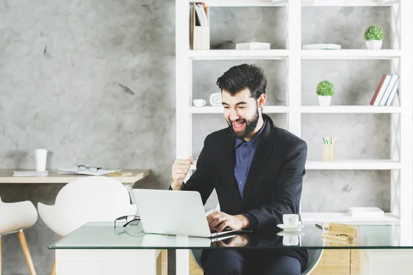 Empresário feliz usando laptop no local de trabalho — Fotografia de Stock