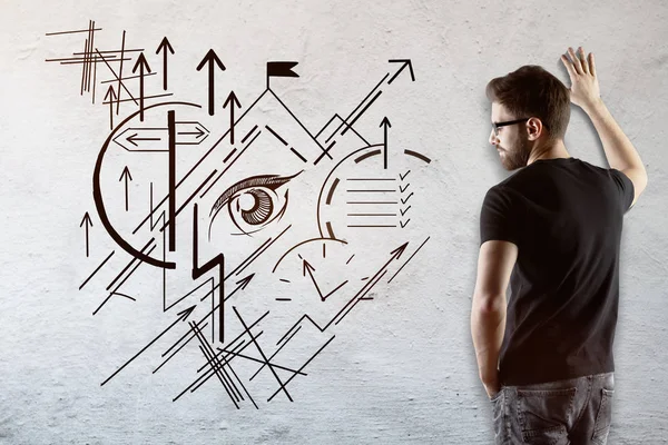 Thoughtful young businessman looking at concrete wall with creative geometric business vision sketch. Success concept — Stock Photo, Image