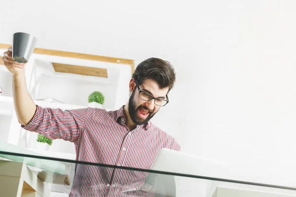 Fröhlicher Mann mit Laptop am Arbeitsplatz — Stockfoto