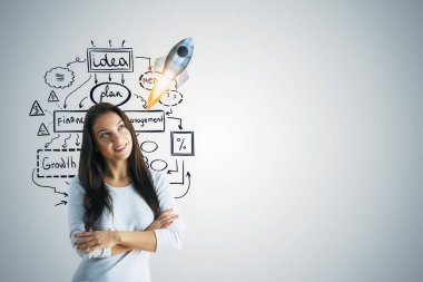 Yaratıcı iş kroki ile gri duvar arka plan üzerinde duran düşünceli genç kadın. Başlangıç kavramı