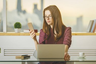 Güzel Bayan smartphone ve dizüstü bilgisayar kullanarak 