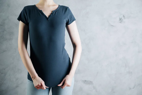 Vista frontal de una mujer joven con camisa azul oscuro casual en blanco y jeans sobre fondo de pared de hormigón. Concepto minorista. Prepárate. — Foto de Stock