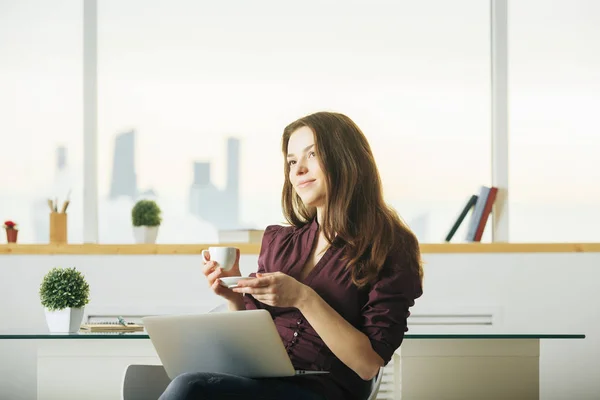 Kvinna med laptop dricka kaffe — Stockfoto