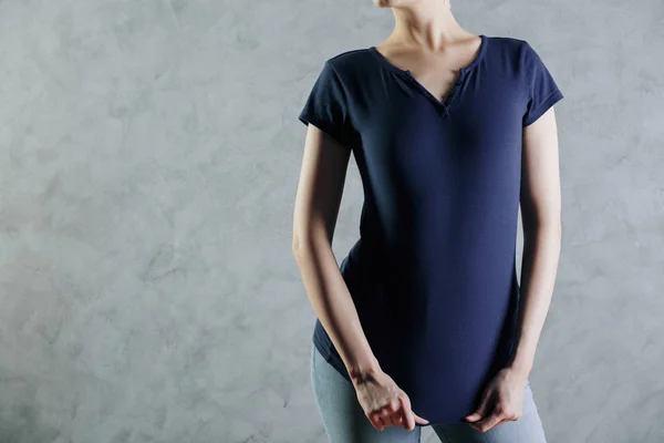 Vista frontal de una mujer joven con camisa azul oscuro casual en blanco y jeans sobre fondo de pared de hormigón. Concepto de diseño. Prepárate. — Foto de Stock