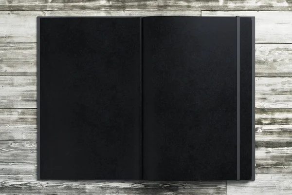 Blank black notepad on wooden desktop — Stock Photo, Image