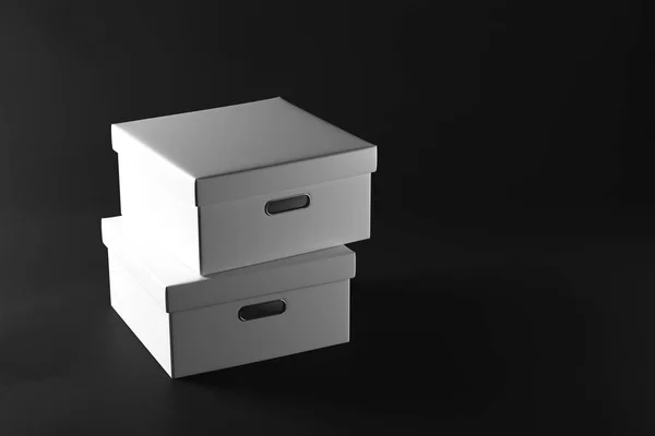 Montones de cajas blancas sobre fondo oscuro. Concepto de embalaje. Renderizado 3D — Foto de Stock