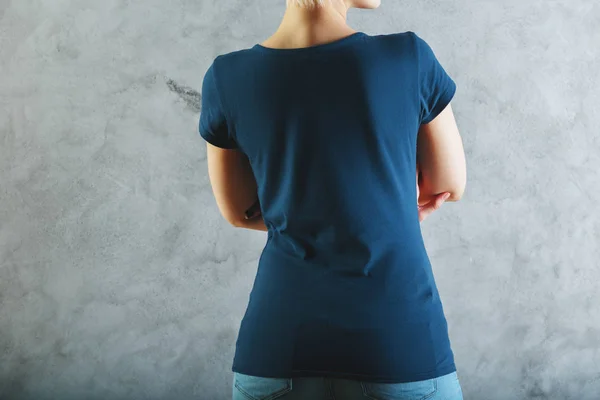 Hátulnézet fiatal nő betonfal háttér üres alkalmi sötét kék inget és farmert visel. Üzlet koncepció. Mintája fel — Stock Fotó