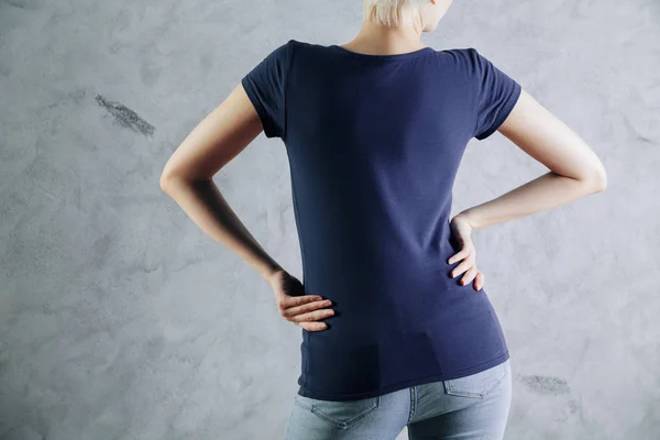 Vista posterior de la mujer joven con camisa azul oscuro casual en blanco y jeans en el fondo de la pared de hormigón. Concepto de ropa. Prepárate. — Foto de Stock