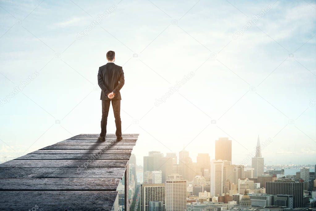 Back view of young businessman on wooden pier looking at city with copy space. Research concept 