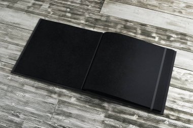 Ahşap masaüstünde temiz siyah not defteri 