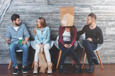 Sandalye üzerinde oturan, alışveriş torbaları, kahve bardağı tutan ve having fun kadın ve erkekler. Dostluk kavramı 