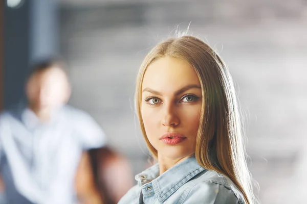 Portret van aantrekkelijke jonge vrouw. Wazig zakenman op de achtergrond. Levensstijl concept — Stockfoto