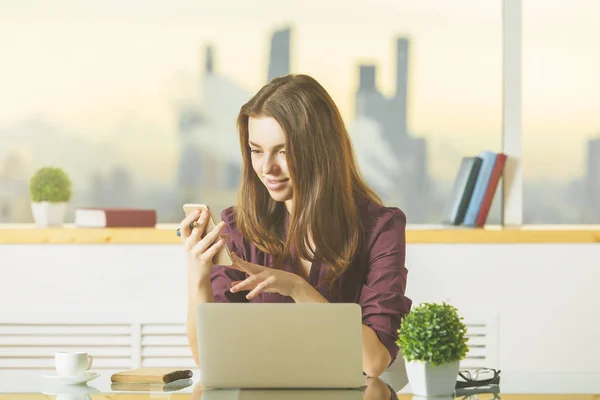 Atraktivní dáma používající mobilní telefon a notebook — Stock fotografie