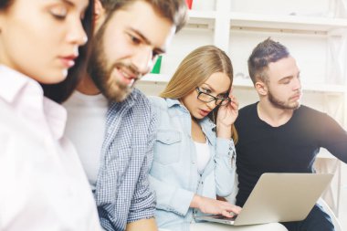 Dizüstü bilgisayar kullanan ve bir şey tartışırken modern ofis genç insanlar. İletişim kavramı 