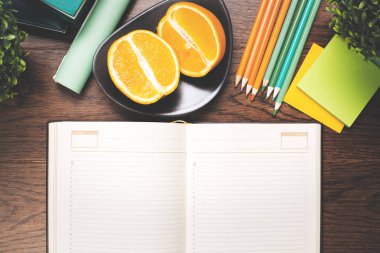 Boş ciltli not defteri ve meyve üstünde okul sırası