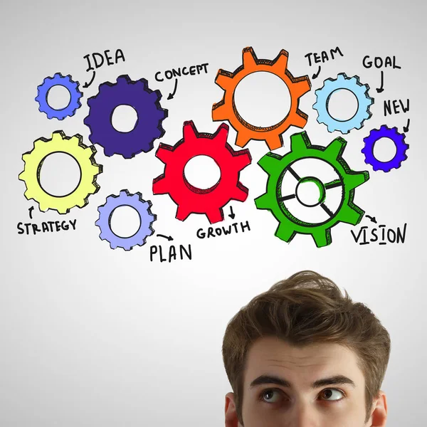 Portret van aantrekkelijke jonge man op de lichtgrijze achtergrond met kleurrijke tandwielen. Teamwork concept — Stockfoto