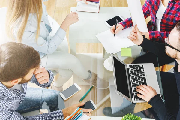 Vue du dessus de l'équipe à l'aide d'un ordinateur portable avec écran vide placé sur un bureau en verre. Concept de communication — Photo