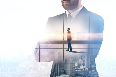 Katlanmış silah üzerinde parlak ofis ve şehir arka plan ayakta ile genç Avrupa iş adamı. Kavram düşünüyorum. Çift pozlama 