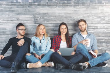 Ahşap duvar ile modern ofis masasında bakimi, öğeleri elinde tutan ve having fun genç Avrupa ekip üyeleri. İletişim kavramı 