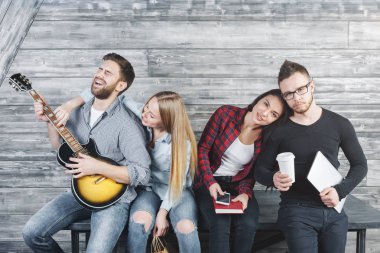 Eğlence ve iletişim evde ahşap iç sahip mutlu arkadaşlar gitar çalmak. İlham kavramı
