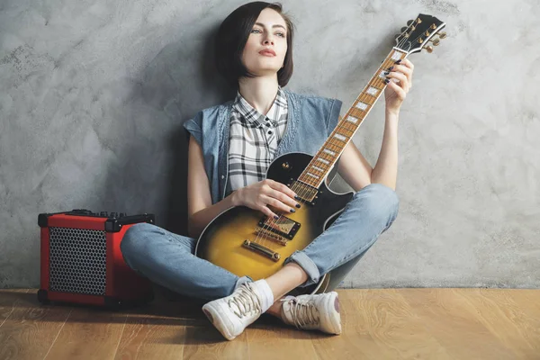 Ελκυστική γυναίκα με κιθάρα στο στούντιο — Φωτογραφία Αρχείου
