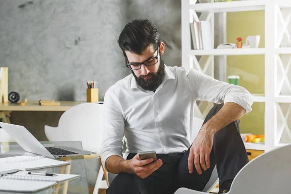 Homem usando laptop e celular — Fotografia de Stock