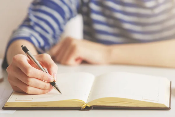 Woman writing in hardcover notepad — Stock Photo, Image