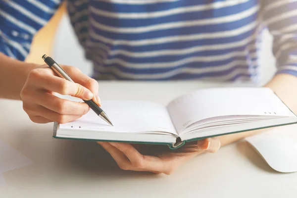 Woman writing in hardcover diary — Stock Photo, Image