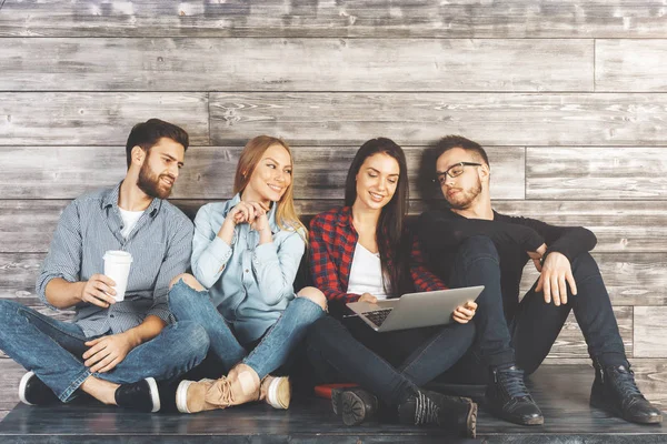 Ahşap duvar ile modern ofis masasında bakimi, öğeleri elinde tutan ve having fun genç Avrupa ekip üyeleri. İşbirliği kavramı 