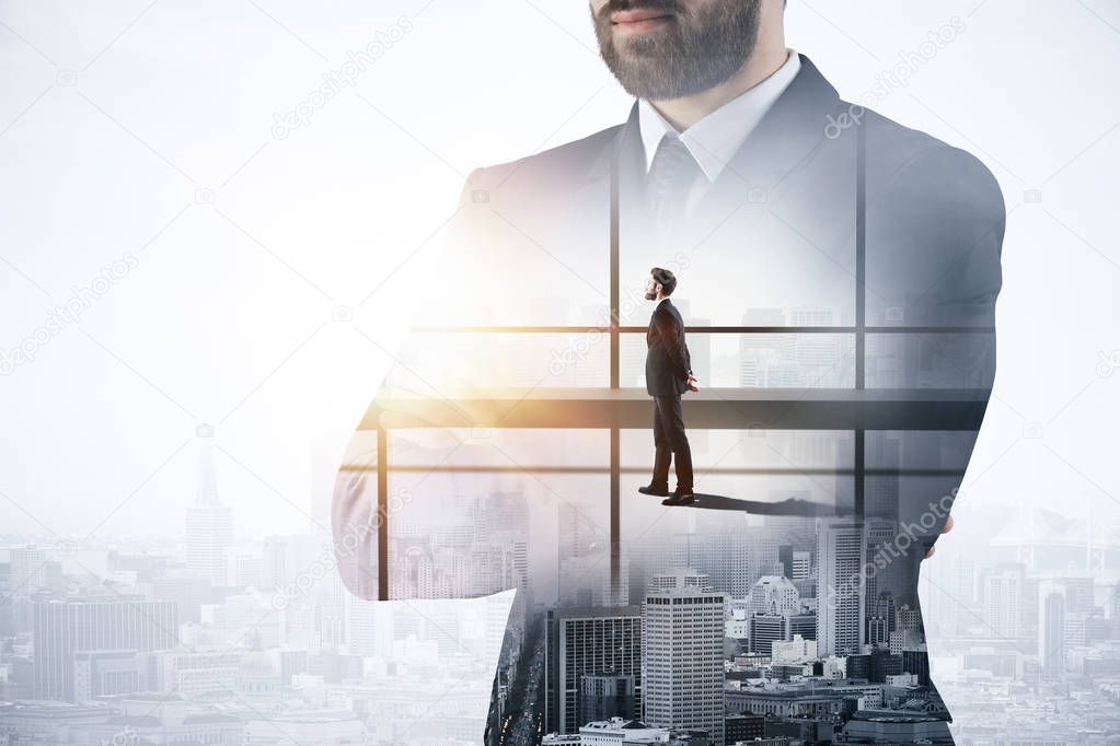 Young european businessman with folded arms standing on bright office and city background. Research concept. Double exposure 