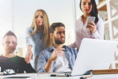 Çekici genç Avrupa grubu, iş erkek ve kadın modern ofis dizüstü, smartphone, evrak ve diğer öğeleri üstünde okul sırası ile proje üzerinde. İletişim kavramı 