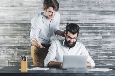 Mutlu adamlar dizüstü bilgisayar kullanarak 