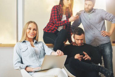 Çekici genç erkek ve kadınların dizüstü bilgisayar ve akıllı telefon kullanma office. Ekip çalışması ve gadget kavramı