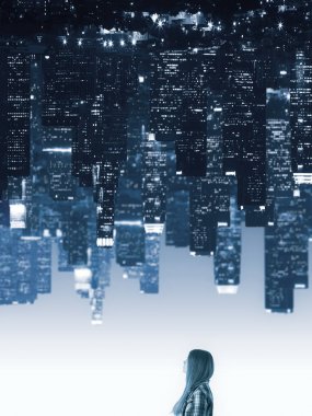 Soyut upside aşağı şehir arka plan üzerinde küçük düşünceli genç kadın. Hayat kavramı 