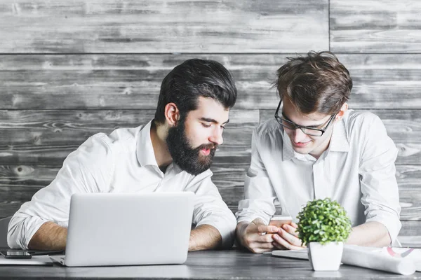 Smartphone kullanarak iki yakışıklı iş adamları 