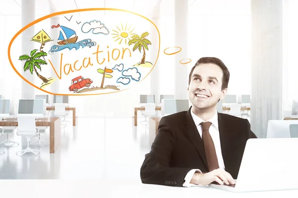 Happy young businessman in modern office using laptop and daydreaming about vacation. Travel concept — Stock Photo, Image